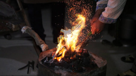 Fire in the blacksmith's forge, close-up of hands