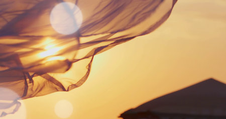 silhouette of a flying fabric against the background of the setting sun
