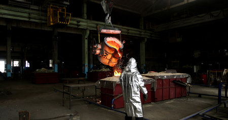 Worker in a metallurgical plant. He is wearing protective clothing.