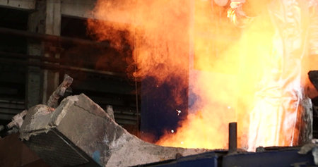 Worker in a metallurgical plant, working with hot coals