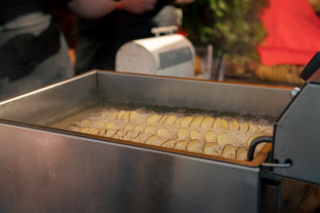 Potatoes are fried in oil at the food festivalの写真素材