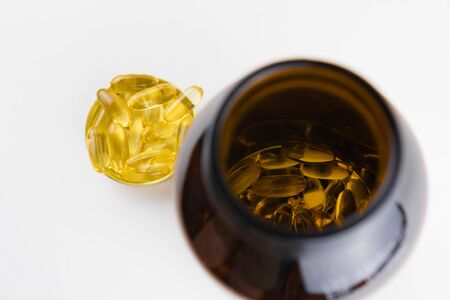 Jar with omega 3 capsules in a cap on a white backgroundの写真素材