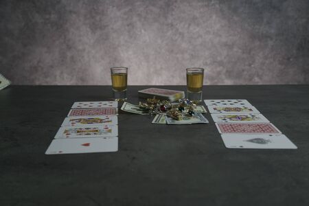 The combination of Flash Royal cards on a gray table with money and gold. Close-up. Poker game