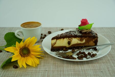Piece of tasty chocolate cake with coffe cup and sunfloweron white backgroundの写真素材