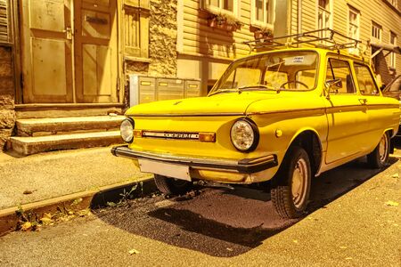Old yellow car designed and built from 1958 at the ZAZ factory in Soviet Ukraine. very popular car in Soviet families. Night photoのeditorial素材