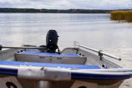 Aluminum fishing boat close up front view, in the background a blurred background of the sea and forestの写真素材