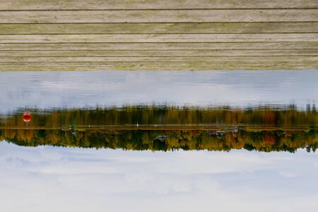 wooden pier for small boats, overlooking the pond and beautiful sky. blank for designers.の写真素材