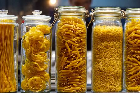 different varieties of pasta in glass jars, close upの写真素材