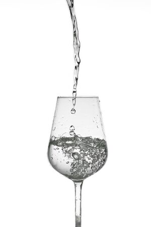 beautiful splashes of water in a wine glass, isolate on white, close up with copy space.の写真素材