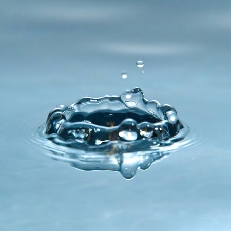 Beautiful splash of water drop on water surface, macro photo