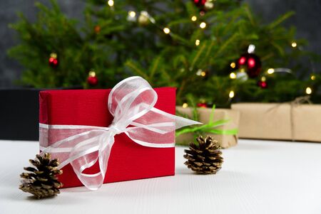 Beautiful Christmas composition. Gift boxes and christmas decor with christmas tree on background. Xmas backdrop for your greeting card with space for text.の写真素材