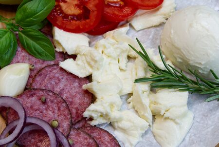 ingredients for cooking italian pepperoni pizza at home. dough, mozarella, salami, tomato, basil, olive oil, rosemary, pepper, garlicの写真素材