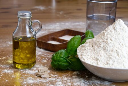 ingredients for making Italian pizza dough at home. flour, salt, sugar, yeast, olive oil and waterの写真素材