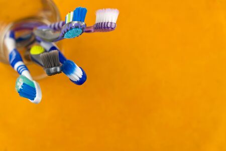 Toothbrushes in glass on orange background - close up top view -Photoの写真素材