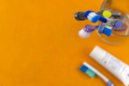 Toothbrushes in glass on orange background - close up top view -Photoの写真素材