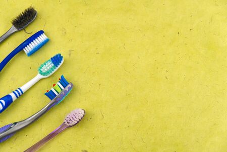 Toothbrushes in glass on yellow background - close up top view -Photo