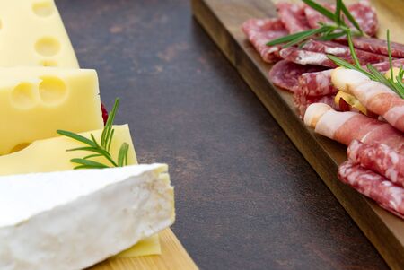 Meat and cheese plate antipasti snack with Prosciutto ham, Parmesan, Blue cheese, Cantaloupe melon and Olives on olive wood serving board on dark stone background.の写真素材