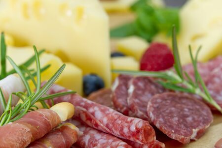 Beautiful sliced food arrangement close-up photo. Italian style antipasto plate, cheese, ham,...