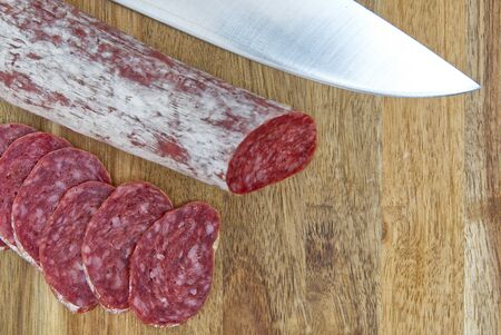 Close-up traditional sliced meat sausage salami on wooden board.の写真素材
