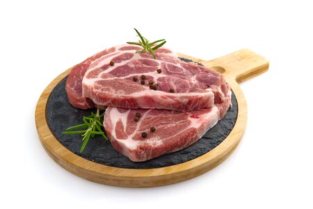 raw pork slices on black stone plate, isolated on white.の写真素材