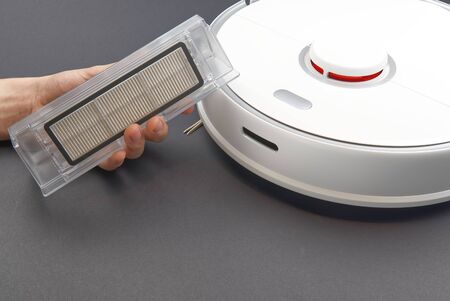 Robot vacuum cleaner, cleaning the trash bin and cleaning the filter. Robot vacuum cleaner isolated...