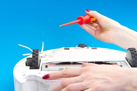 white robot vacuum cleaner. Vacuum cleaner robot repair concept on blue background. technology robot