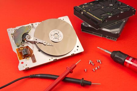 Disassembled hard disk on red Lush lava background.
