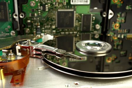 Close up inside of Hard disk drive - HDD . Detail of writing reading head on acuator arm and axis, spindle and platters. Hard disk for PCs, databases, banks, storage of personal data requires virus protection and timely maintenanceの写真素材