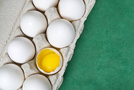 Paper Egg Tray with white eggs. chicken white eggs close up. broken chicken white egg. eggs on green...