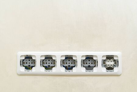 White socket outlets on beige wall witout cover. copy space. eu standart electric outlets.