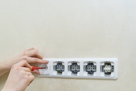 Electrician install outlets on beige wall with eu standards