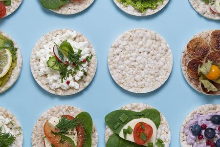 set of rice cakes on light blue background. healfy food rice cake sandwich isolated on light blue...