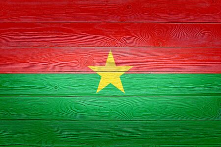 Burkina Faso flag painted on old wood plank background. Brushed natural light knotted wooden planks board texture. Wooden texture background flag of Burkina Fasoの写真素材