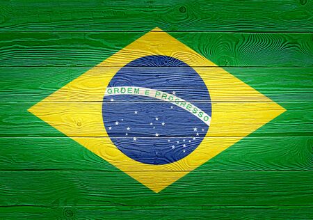 Brazil flag painted on old wood plank background. Brushed natural light knotted wooden planks board texture. Wooden texture background flag of Brazilの写真素材