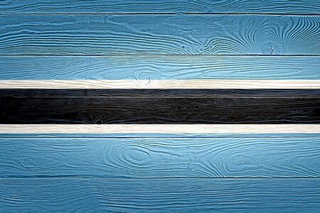 Botswana flag painted on old wood plank background. Brushed natural light knotted wooden board texture. Wooden texture background flag of Botswana.の写真素材