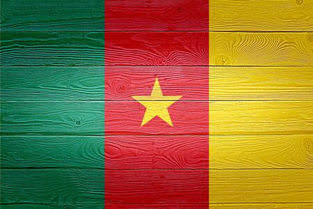Cameroon flag painted on old wood plank background. Brushed natural light knotted wooden board texture. Wooden texture background flag of Cameroon.の写真素材