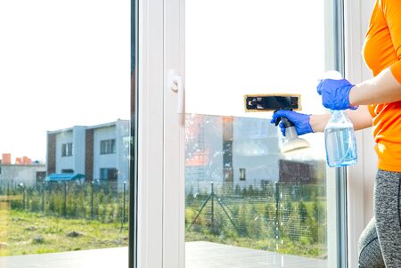 Spring washing of a dirty window. service for washing windows in Domestic homes. a woman in blue...