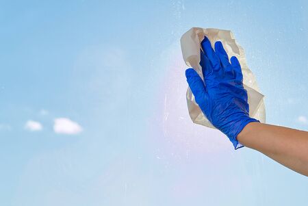 Spring washing a dirty window on a background of clear blue sky. service for washing windows in...