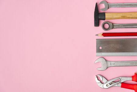 Home maintenance, service, diy concept. Tools for wood, metal and other construction work. Top view on DIY tools. home repairs. on pink background.の写真素材