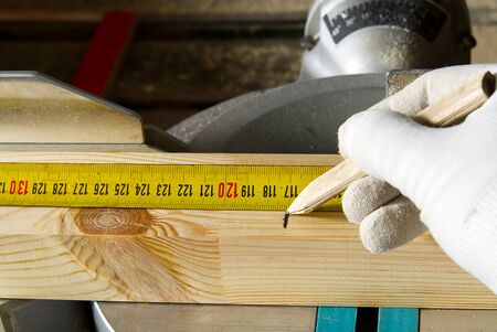 Closeup of professional cabinet makers working Measuring tape at woodworking workshop. Wood material...