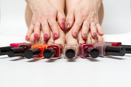 Woman at home spa doing pedicure to herself in white background, close-up.の写真素材