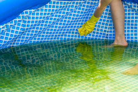 Cleaning pvc inflatable swimming pool, Cleaning the dirty empty pool of algae, The beginning of the swimming season in the hot summer. Cleaning service concept.の写真素材