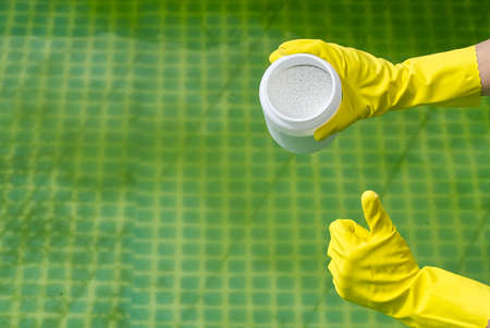 addition of chlorine powder for the pool to remove algae and disinfect water. inflatable swimming pool care concept.の写真素材