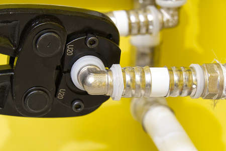 Worker connecting alupex pipes with a tap. Hand press for water pipes PEX - AL - PE-X. plumbing...