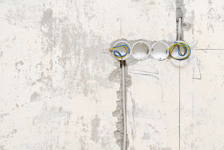 Holes in a concrete wall for installing plastic boxes under sockets. installation of sockets in a...