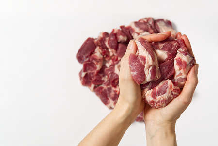 chopped raw pork in hands. A woman holding fine cut pork meat a sign white background. Fine pork meat concept.の写真素材