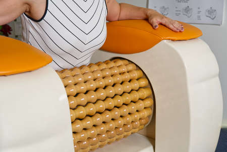woman making massage for stomach. Roll Massage machine is a way to shape the figure. Skin Care, body care concept. modern relax massage equipment.の写真素材