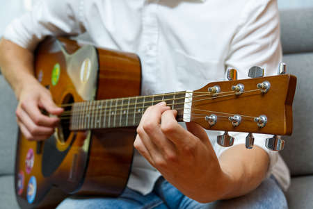 Young boy playing guitar. Close-up of man hand playing classic guitar. teenager learning playing...