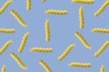 Fusilli pasta random flat lay on blue background without shadow. can be used as raw pasta background, poster, banner not pattern.の写真素材