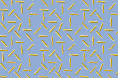 Fusilli pasta random flat lay on blue background without shadow. can be used as raw pasta background, poster, banner not patternの写真素材
